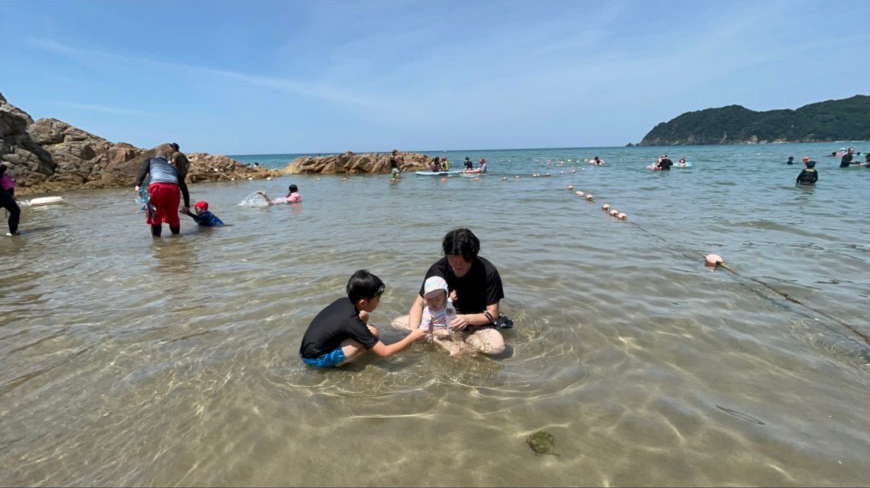 子供と海で遊んでいる画像